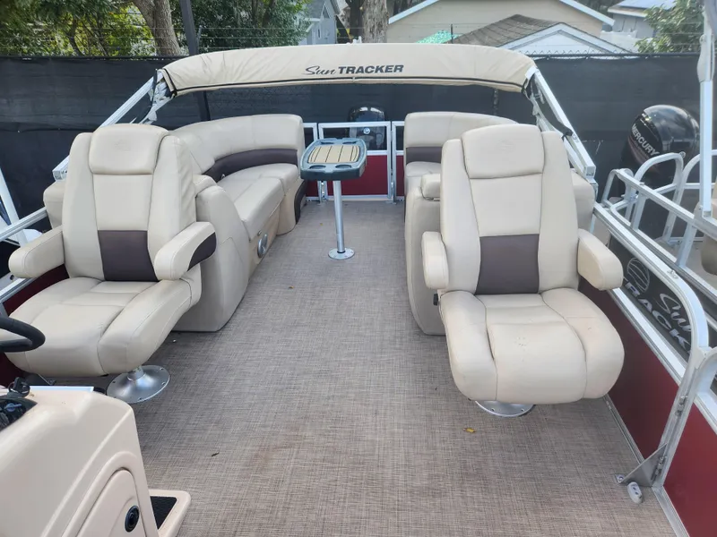 Slide: The Image of 2019 Sun Tracker 24 DLX Party Barge interior with beige seating and table. - 6