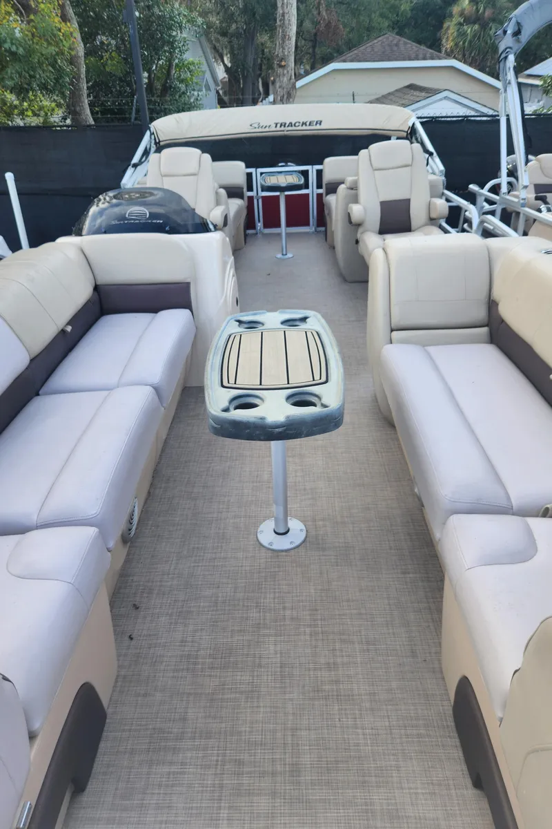 Slide: The Image of 2019 Sun Tracker 24 DLX Party Barge interior with beige seating and central table. - 7