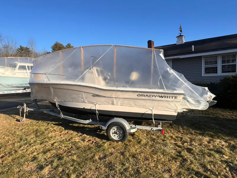Slide: The Image of 2001 Grady-White Sportsman 180 boat covered on trailer, parked on grass. - 16