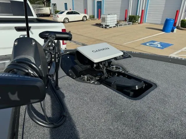 Slide: The Image of 2025 iKon LXL21 boat with powerful outboard motor, parked near a garage. - 6