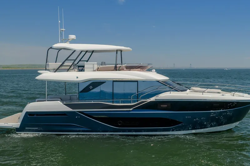 Slide: The Image of 2026 Prestige F5.7 yacht cruising on open water under clear blue sky. - 2