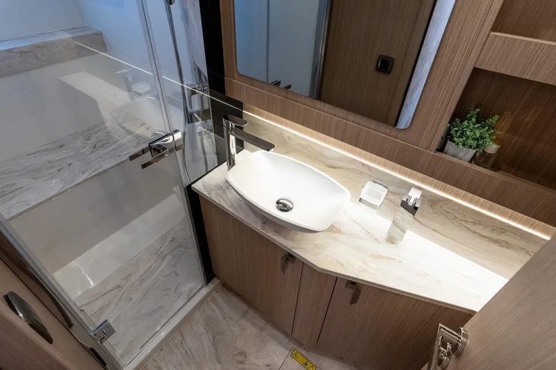Slide: The Image of Modern bathroom in Prestige F5.7 yacht, featuring sleek sink, glass shower, and elegant wood finishes. - 80