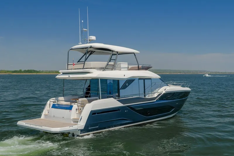 Slide: The Image of Luxury 2026 Prestige F5.7 yacht cruising on open water under clear blue skies. - 4