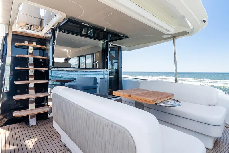 Slide: The Image of Luxurious 2026 Prestige F5.7 yacht interior with ocean view, featuring elegant seating and wooden accents. - 39