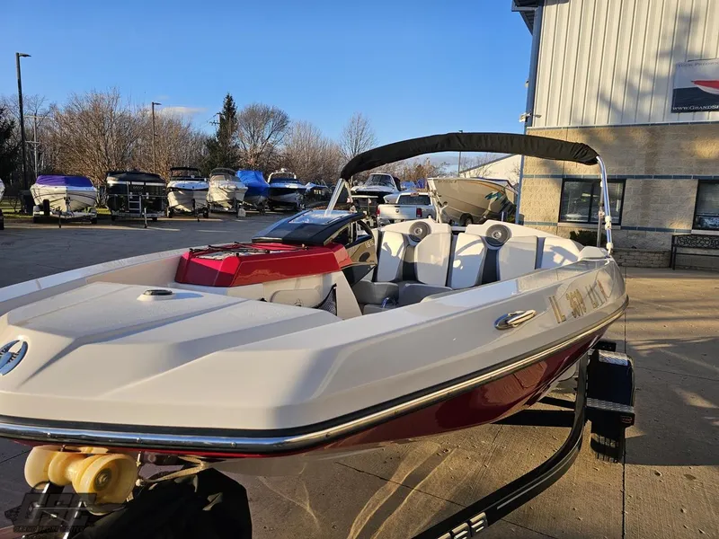 Slide: The Image of 2018 Scarab 165 ID boat with red and white design, parked outdoors. - 10