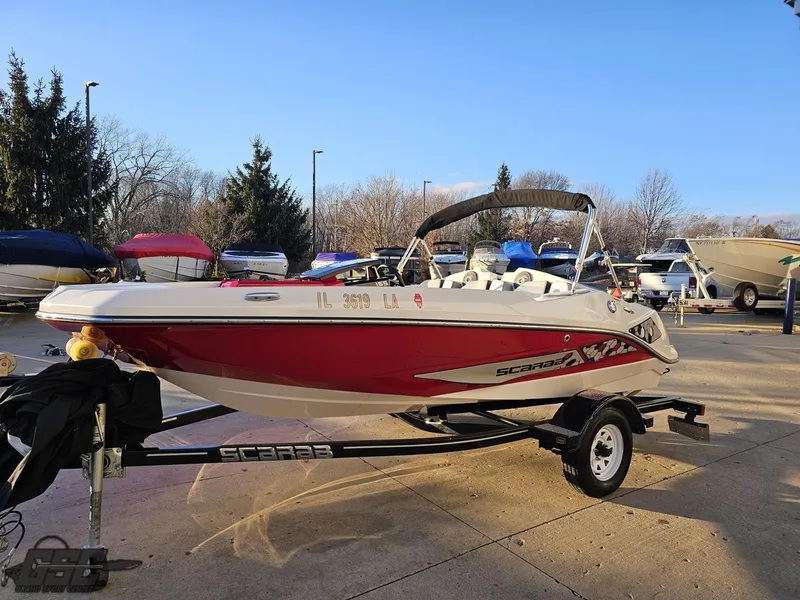 Slide: The Image of 2018 Scarab 165 ID boat on trailer, red and white, parked outdoors. - 13