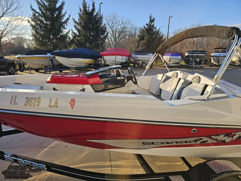 Slide: The Image of 2018 Scarab 165 ID boat with red and white design, parked outdoors. - 16
