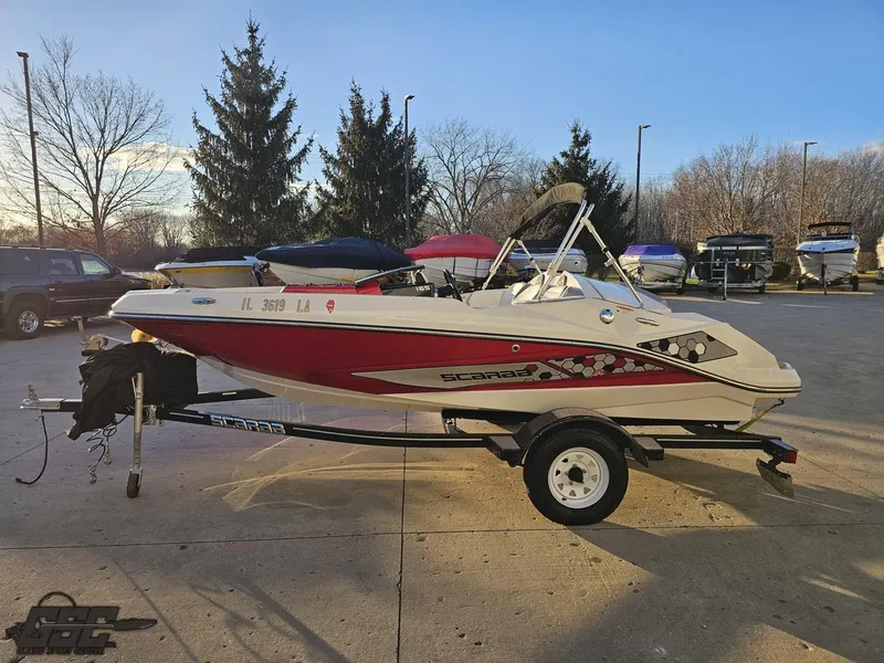 Slide: The Image of 2018 Scarab 165 ID boat on trailer in parking lot, sunny day. - 18
