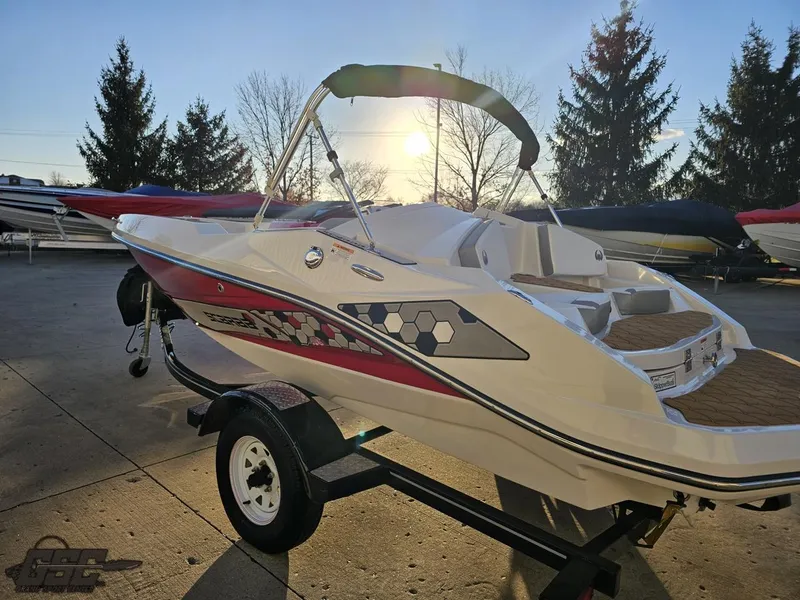 Slide: The Image of 2018 Scarab 165 ID boat on trailer, sunlit, with vibrant graphics. - 22