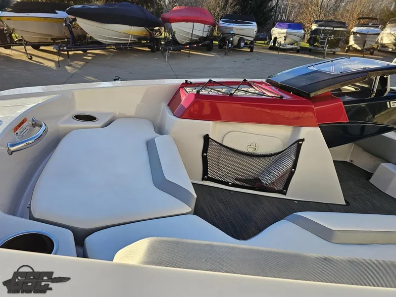 Slide: The Image of 2018 Scarab 165 ID boat interior with seating and storage, surrounded by other boats. - 32