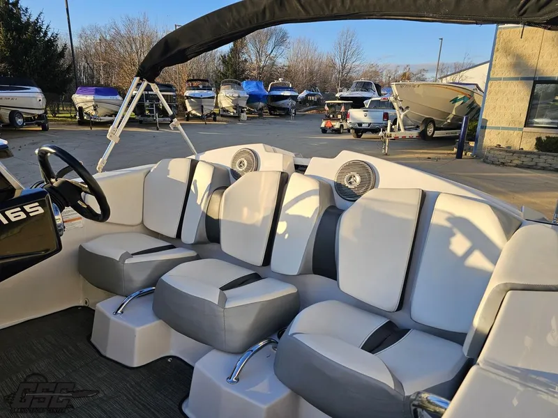 Slide: The Image of 2018 Scarab 165 ID boat interior with white and gray seating, parked outdoors. - 34