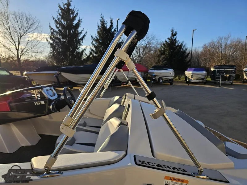 Slide: The Image of 2018 Scarab 165 ID boat with sleek design and chrome accents in a marina setting. - 36