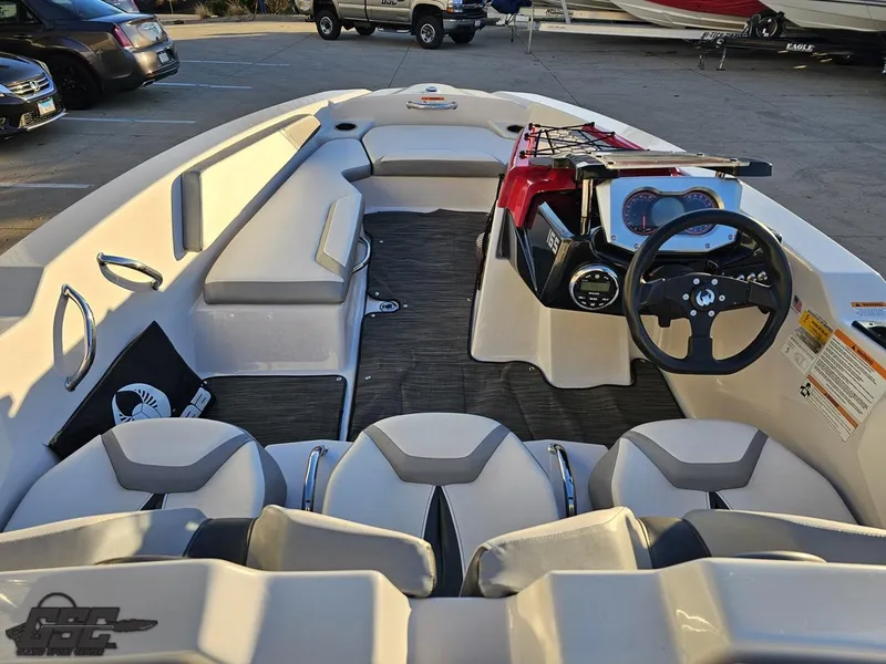Slide: The Image of 2018 Scarab 165 ID boat interior with seating and steering wheel in a parking lot. - 41