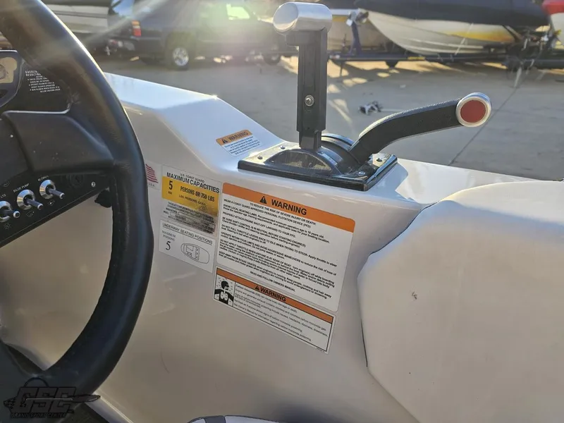 Slide: The Image of 2018 Scarab 165 ID boat control panel with warning labels and throttle lever. - 49