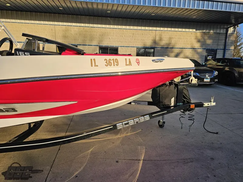 Slide: The Image of 2018 Scarab 165 ID boat on trailer, red and white design, parked outdoors. - 7