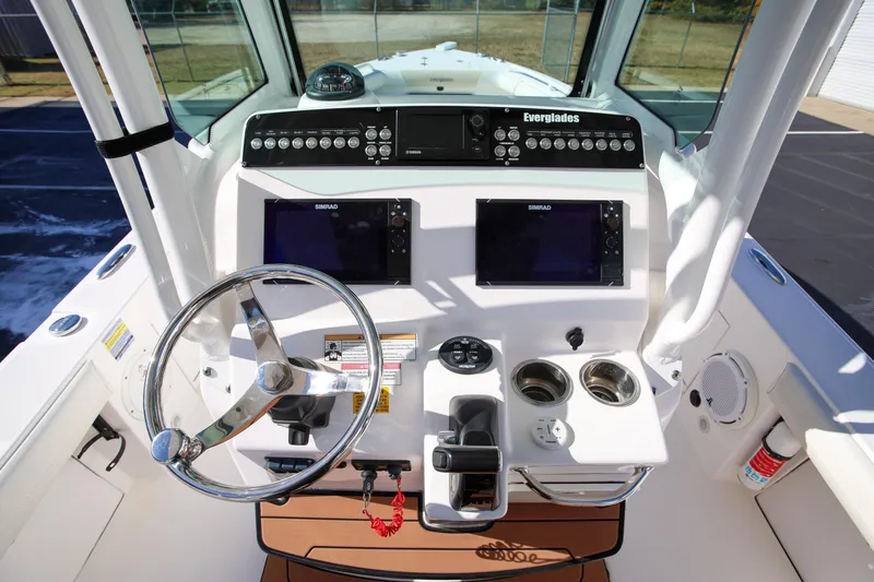 Slide: The Image of 2017 Everglades 253 Center Console boat dashboard with steering wheel and navigation displays. - 16