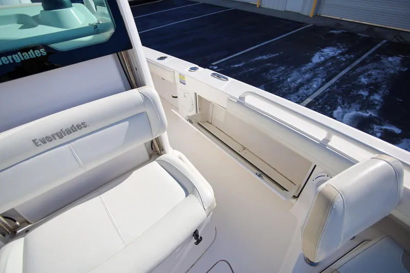 Slide: The Image of 2017 Everglades 253 Center Console boat interior with white seating and storage compartment. - 25