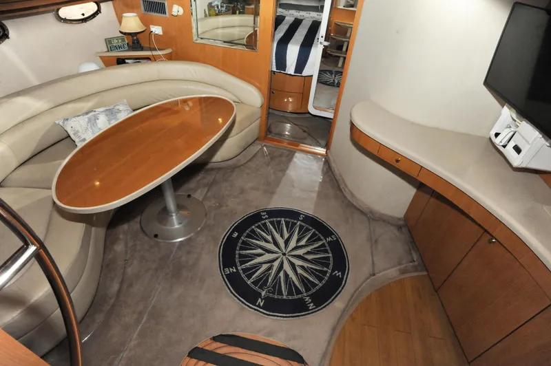 Slide: The Image of Interior of 2001 Regal Commodore 4160 yacht with seating, table, and compass-themed rug. - 14