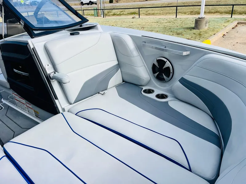 Slide: The Image of 2020 Malibu Wakesetter 24 MXZ interior with white and gray seating, cup holders, and speaker. - 13