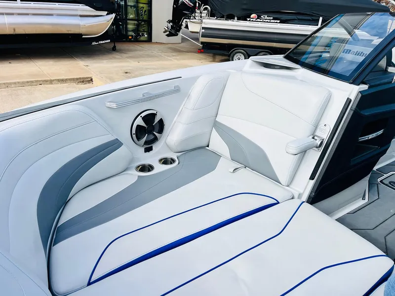 Slide: The Image of 2020 Malibu Wakesetter 24 MXZ interior with white and gray seating, cup holders, and speaker. - 14