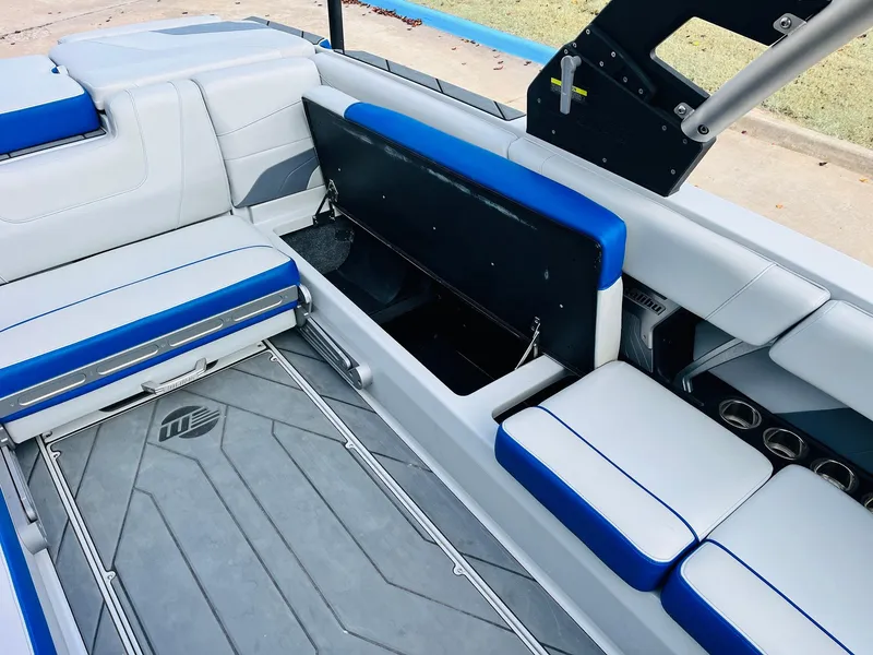 Slide: The Image of 2020 Malibu Wakesetter 24 MXZ interior with blue and white seating and storage compartment. - 26