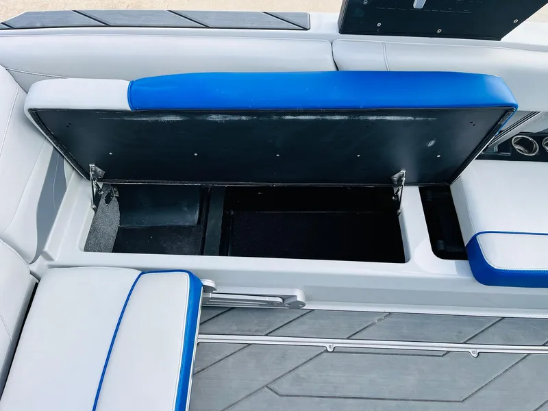 Slide: The Image of 2020 Malibu Wakesetter 24 MXZ interior storage compartment with blue and white seating. - 27