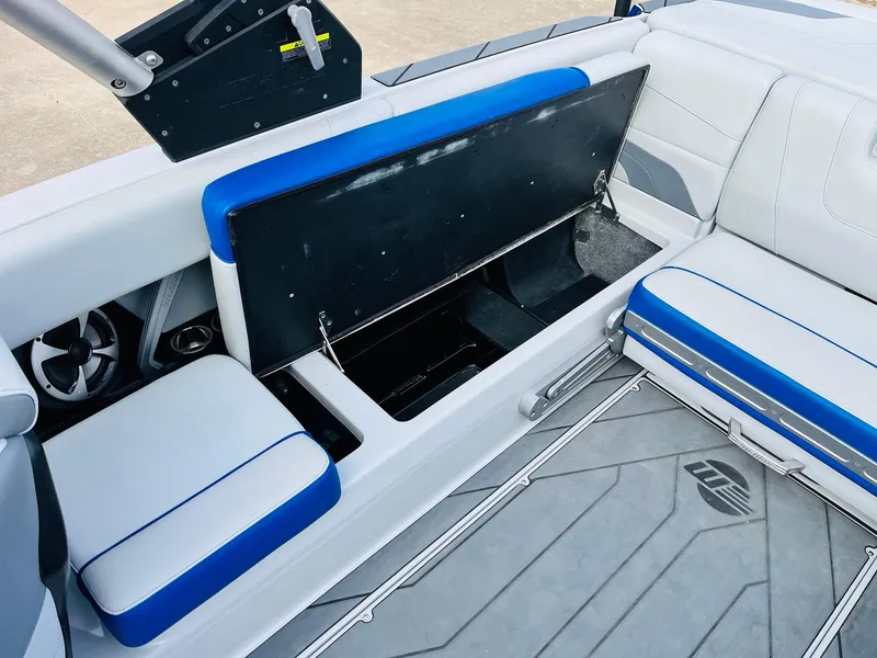 Slide: The Image of 2020 Malibu Wakesetter 24 MXZ interior seating with storage compartment open. - 33