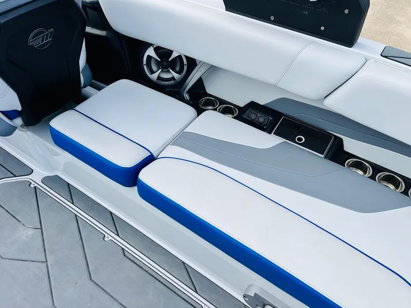 Slide: The Image of 2020 Malibu Wakesetter 24 MXZ interior with white and blue seating, cup holders, and speaker. - 36