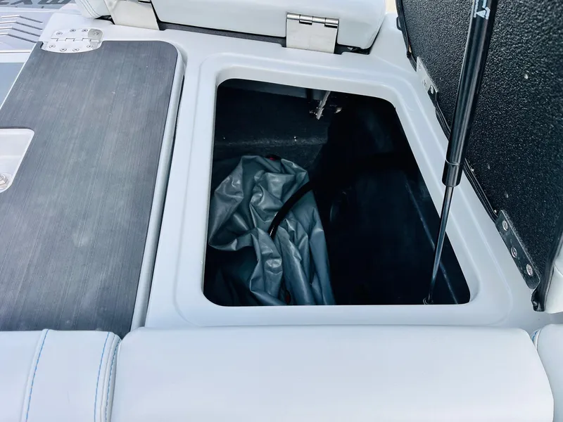 Slide: The Image of 2020 Malibu Wakesetter 24 MXZ storage compartment with open lid. - 48