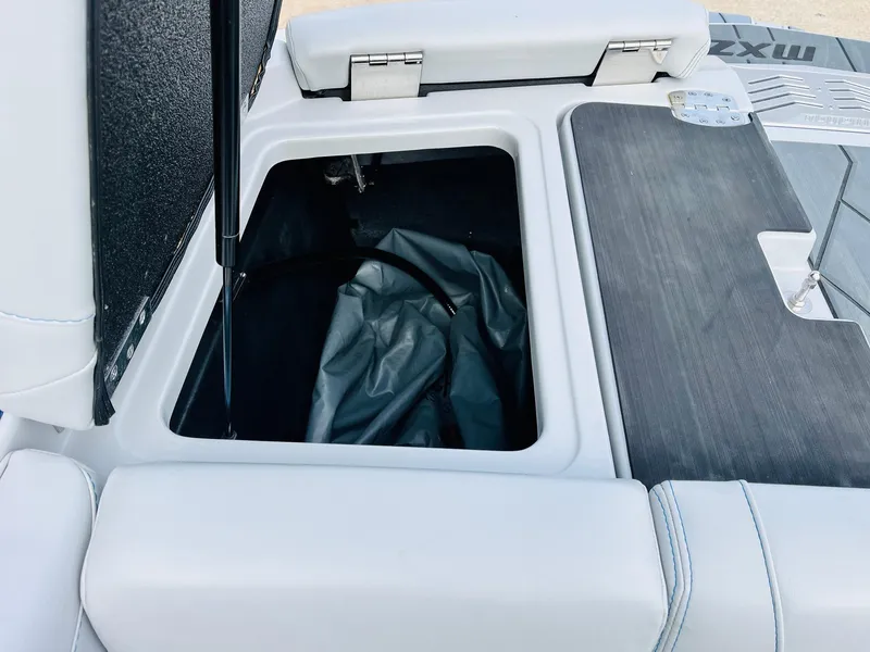 Slide: The Image of 2020 Malibu Wakesetter 24 MXZ storage compartment with open lid and interior view. - 49