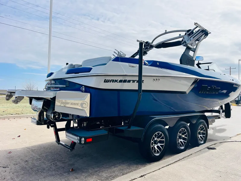Slide: The Image of 2020 Malibu Wakesetter 24 MXZ boat on trailer, blue and white design. - 5