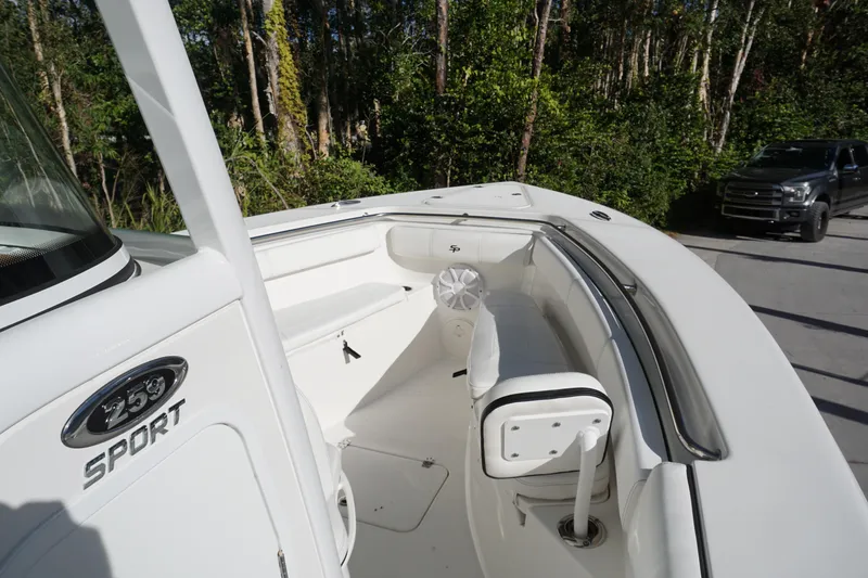 Slide: The Image of 2021 Sea Pro 259 Center Console boat with spacious seating, parked near a forested area. - 11