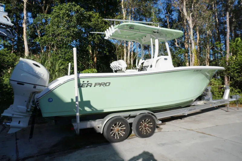 Slide: The Image of 2021 Sea Pro 259 Center Console boat on trailer, parked outdoors. - 2