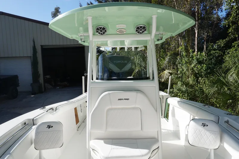 Slide: The Image of 2021 Sea Pro 259 Center Console boat with white seating and green canopy. - 3