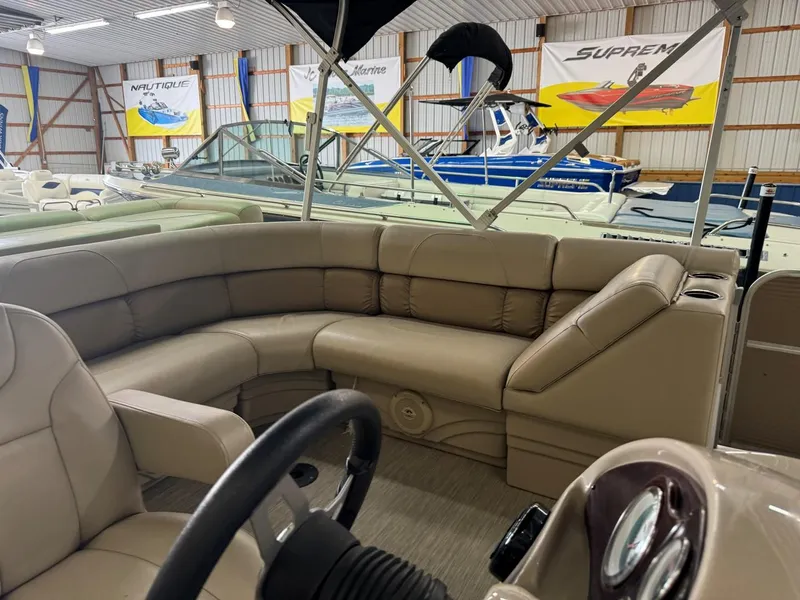 Slide: The Image of 2018 Misty Harbor 2085 Adventure CR pontoon boat interior with beige seating in showroom. - 7