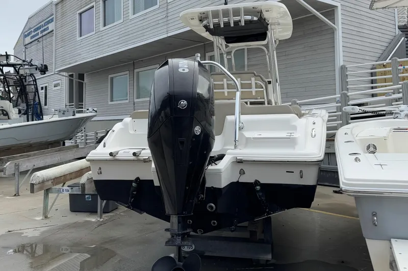 Slide: The Image of 2021 Key West 239 FS boat with outboard motor, docked near a building. - 3