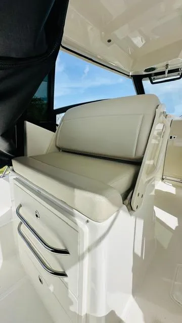 Slide: The Image of 2023 Boston Whaler 325 boat interior with cushioned seating and storage. - 10