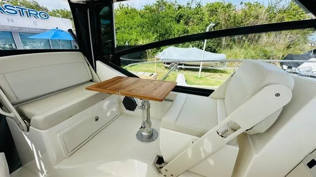 Slide: The Image of Interior of 2023 Boston Whaler 325 boat with seating and wooden table. - 12