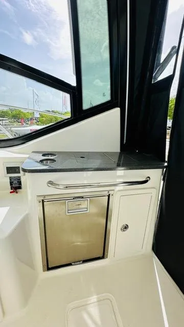 Slide: The Image of 2023 Boston Whaler 325 interior with sleek kitchenette and stainless steel accents. - 13