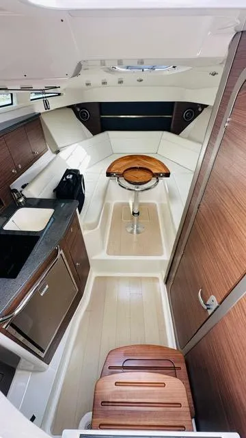 Slide: The Image of 2023 Boston Whaler 325 cabin interior with modern amenities and wood accents. - 15