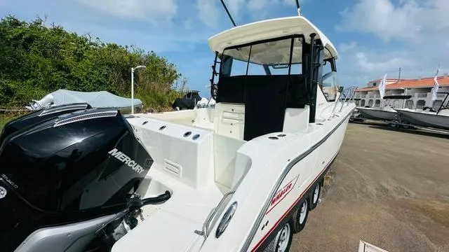 Slide: The Image of 2023 Boston Whaler 325 boat with Mercury engine, parked outdoors under a blue sky. - 4