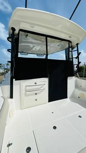 Slide: The Image of 2023 Boston Whaler 325 boat interior with storage drawers and black cover. - 7