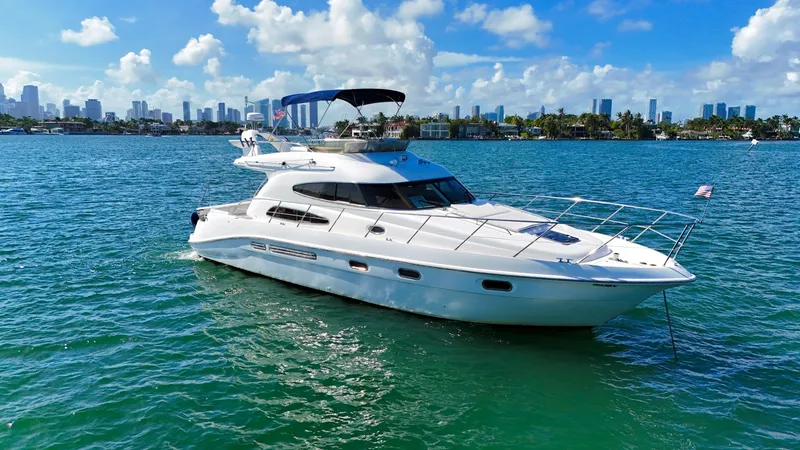 Slide: The Image of 2004 Sealine 47 yacht on blue water with city skyline in background. - 1