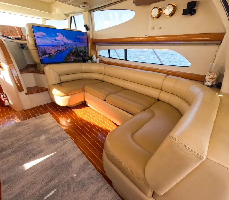 Slide: The Image of Luxurious 2004 Sealine 47 yacht interior with leather seating, wood flooring, and large TV. - 14