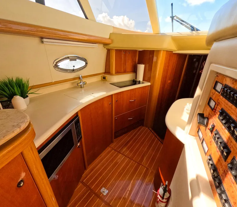 Slide: The Image of Luxurious 2004 Sealine 47 yacht interior with modern kitchen and wooden cabinetry. - 22
