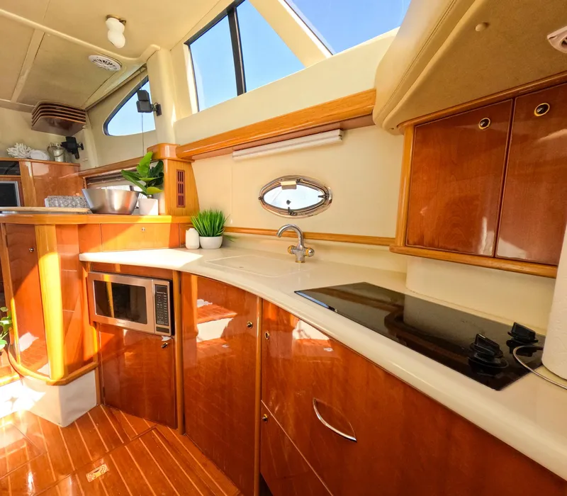 Slide: The Image of Luxurious 2004 Sealine 47 yacht kitchen with modern appliances and elegant wood finish. - 23