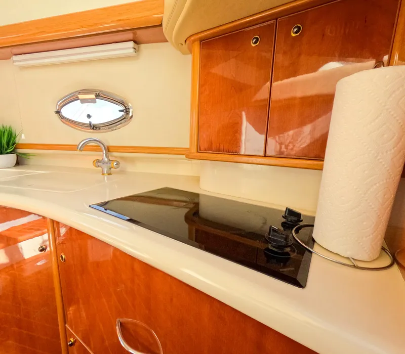 Slide: The Image of Luxurious kitchen area in a 2004 Sealine 47 yacht with wooden cabinets and modern amenities. - 24