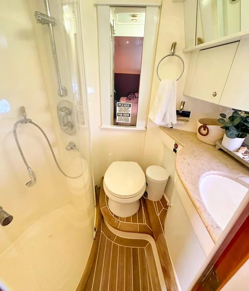 Slide: The Image of 2004 Sealine 47 yacht bathroom with shower, toilet, sink, and wooden flooring. - 26