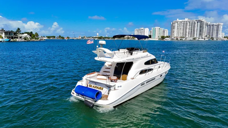 Slide: The Image of 2004 Sealine 47 yacht cruising on blue waters with city skyline in the background. - 9