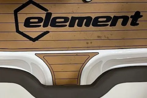 Slide: The Image of Bayliner Element E18 2023 boat deck with logo and wood finish. - 4